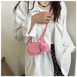 Détail du sac selle rose avec gaufrage de dessin animé et pompon en fourrure douce