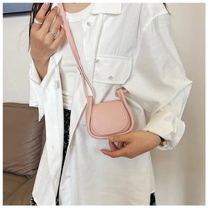 Mini borsa a tracolla rosa su modella con texture in pelle liscia e design a patta