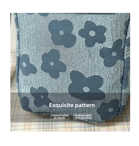 Gros plan sur un tissu tricoté bleu à motifs floraux et texture jacquard détaillée