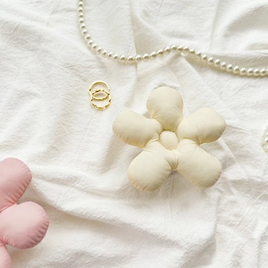 Gros plan d'un support de téléphone en fleur pelucheuse sur tissu blanc avec perles