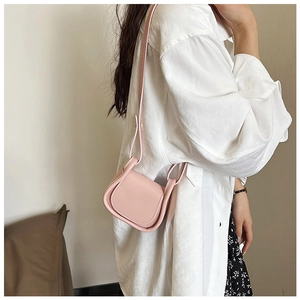 Mini borsa a tracolla rosa indossata da una modella con gonna a fiori e camicia