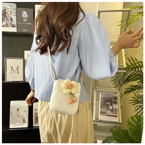 Détail du sac bandoulière en toile blanche avec fleurs 3D jaunes et décorations