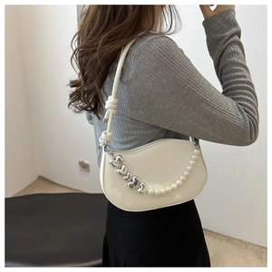 Détail du sac demi-lune blanc avec chaîne décorative de cœurs argentés et de perles