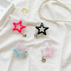 Detail of glitter heart and star phone grips in vibrant colors on white fabric