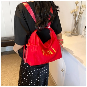 Large red nylon tote bag with yellow Hai embroidery shown as a stylish shoulder bag