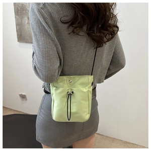 Minimalist light green canvas phone bag shown cross-body on a model for size reference