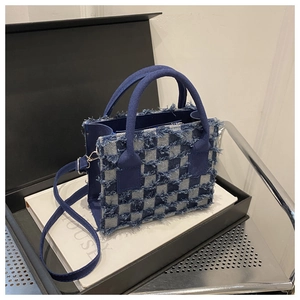 Nahaufnahme der blauen Schachbrett-Tasche mit ausgefransten Kanten und Schultergurt