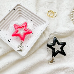 Detail of glitter heart phone grips with star pendants on a marble tray background