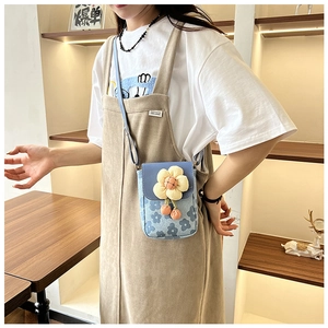 Détail du petit sac à bandoulière floral bleu avec une fleur de tournesol tricotée jaune