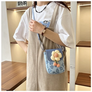 Détail du sac bandoulière bleu à fleurs avec tournesol et texture en toile épaisse