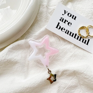 Close-up of heart-shaped glitter phone grip with star pendant and pink gradient star panel