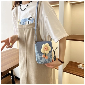 Détail du mini sac bandoulière bleu à fleurs avec une grande fleur jaune 3D en tissu sur toile