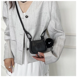 Mini sac selle en PU noir avec gaufrage dessin animé et pompon porté par un mannequin