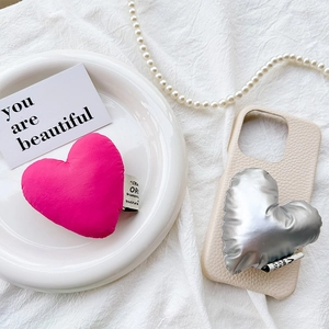 Detail of plush heart phone grip with premium leather texture and luxury accessories
