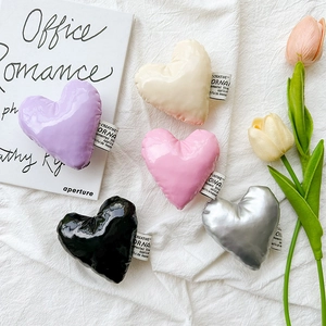 Flat lay of heart-shaped faux leather phone grips in purple, beige, pink, black, and silver