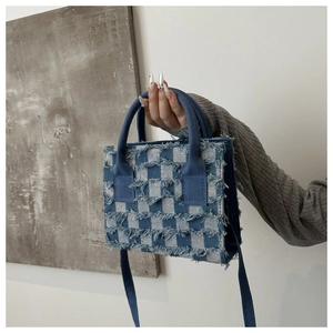 Detail der blau-weißen Karo-Denim-Tasche mit modischen Fransen an den Kanten
