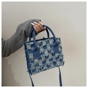 Details der blau-weißen karierten Denim-Textur mit ausgefransten Kanten und Quasten