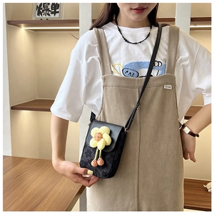Détail du mini sac bandoulière noir avec grande fleur jaune en 3D sur tissu textile