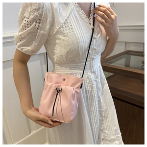 Pink minimalist crossbody phone bag featuring drawstring pleats and metal button detail