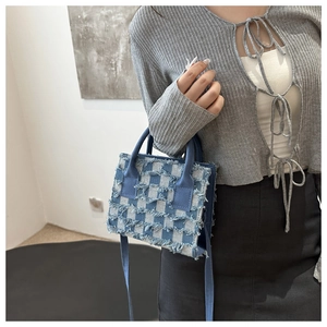 Blaue Denim-Umhängetasche mit Schachbrettmuster und Fransen an einem weiblichen Model