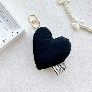 Detail view of heart-shaped black fabric phone grip with creative white woven label