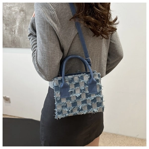 Rückansicht eines Models mit blau karierter Denim-Handtasche und Fransen-Details