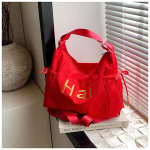 Detail of red nylon Hobo bag with gold Hai logo embroidery and drawstring bow decoration