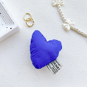 Macro detail of plush heart phone socket in cobalt blue with textile creative label