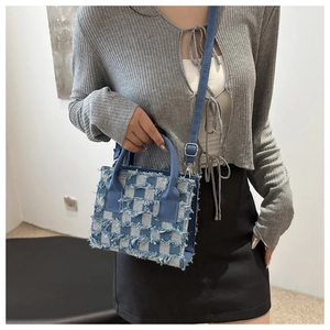 Nahaufnahme der blauen Denim-Umhängetasche mit Karomuster, Fransen und Metallschnalle