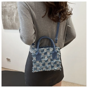 Blaue karierte Denim-Handtasche mit Fransen-Detail an der Schulter eines Models