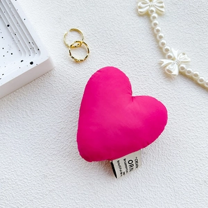 Detail of rose pink heart-shaped fabric phone grip with decorative woven label