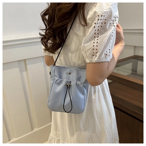 Detailweergave van de lichtblauwe nylon mini crossbody tas met trekkoord bij een model