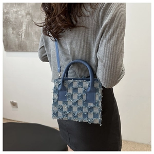 Nahaufnahme der blauen karierten Umhängetasche mit Fransen und Denim-Textur