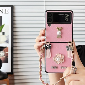 Dettaglio custodia Z Flip in pelle rosa con perle di camelia e decoro di orso di lusso