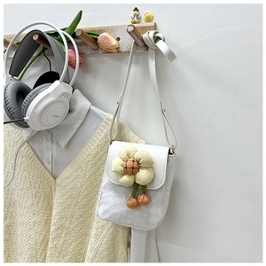 Détail d'un mini sac bandoulière blanc orné d'une grande fleur jaune en relief 3D