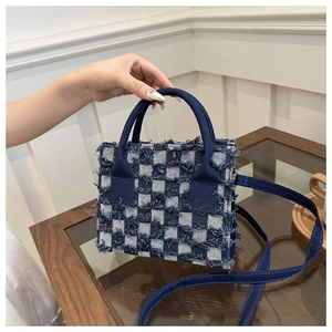 Detail der blau-weiß karierten Handtasche mit einzigartigem Fransenrand-Design