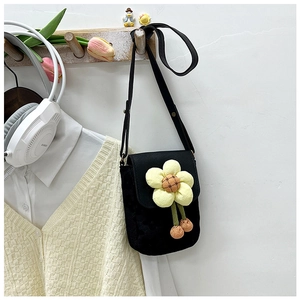 Détail d'un mini sac bandoulière noir orné d'une grande fleur de soleil en peluche jaune