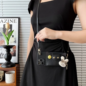 Detail of iPhone case with card holder, yellow smiley face badge and crossbody strap
