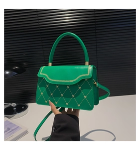 Close-up of green PU leather crossbody bag with gold heart embroidery and quilted pattern