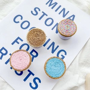 Detail of four woven phone socket grips in pink, blue, wood, and rainbow colors