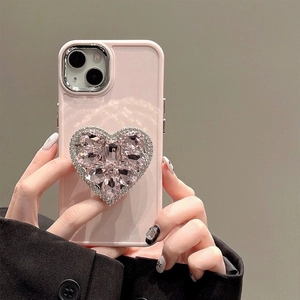 Gros plan détaillé d'une coque iPhone rose avec un support en forme de cœur en strass brillant