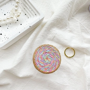 Top view of a woven colorful phone socket on a textured white fabric background