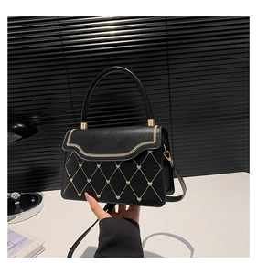 Detail view of black PU leather bag with heart embroidery and gold wave stitching
