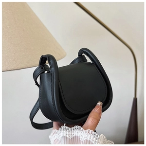Primo piano di una mini borsa a tracolla in pelle nera opaca con cuciture eleganti