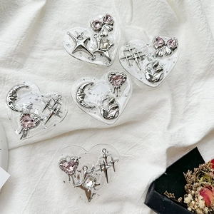 Macro view of five heart-shaped resin charms with silver metal motifs and rhinestones