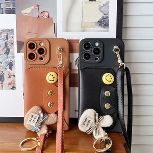 Detail of leather crossbody card holder phone cases with charms and smiley face pins