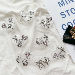 Close-up of heart-shaped resin phone grips with silver moon and star embellishments