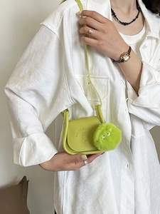 Sac bandoulière minimaliste vert avec pendentif en peluche et détail gaufré de personnage