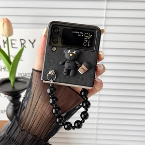 Detail of Galaxy Z Flip case with black quilted texture, coffee bear charm and pearl strap