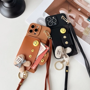 Leather iPhone case with wallet slot, crossbody strap, and plush rabbit charm